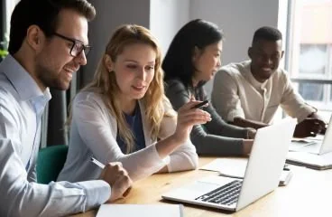 Equipo participando en una capacitación con computadores