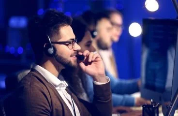 Profesional de soporte con auriculares frente a un computador
